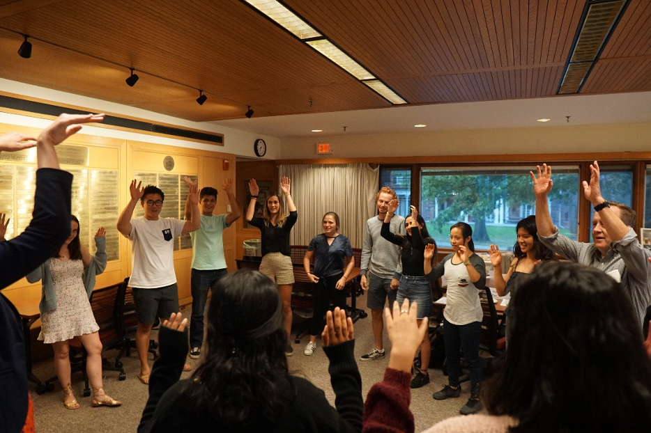 Group of students with their hands in the air in a circle
