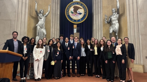 The First-Year Fellows stand in front of the seal of the Department of Justice.