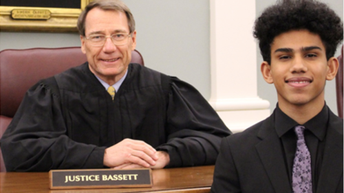 Justice Bassett sitting at his bench in robes with student Devontae Lacasse