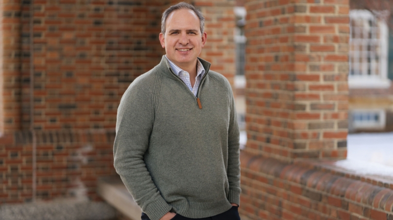 Jason Barabas stands outside in front of a brick building.