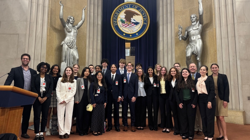 The First-Year Fellows stand in front of the seal of the Department of Justice.