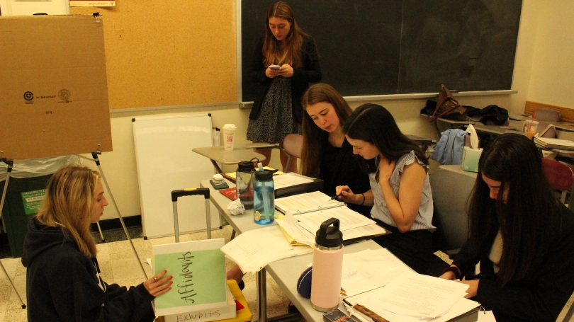 Members of the mock trial team prepare for a trial in a classroom