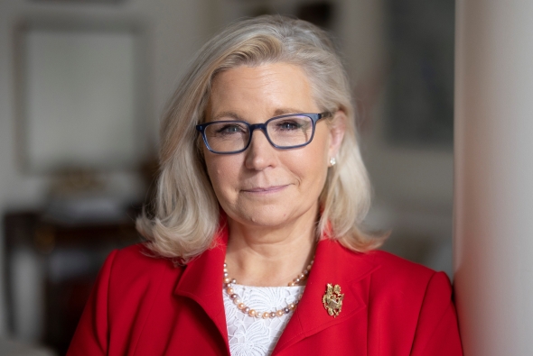 A headshot of Liz Cheney. She is wearing a red suit jacket.