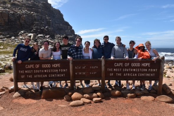 A group photo in front of ta sign that reads Cape of Good Hope, The most south-Western point of the African continent.