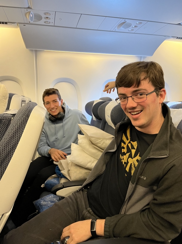Jason and Kyle with lots of pillows between them on the plane.
