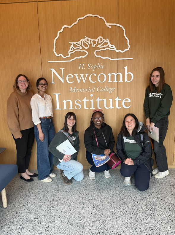 The students in front of a sign that says Newcomb Institute
