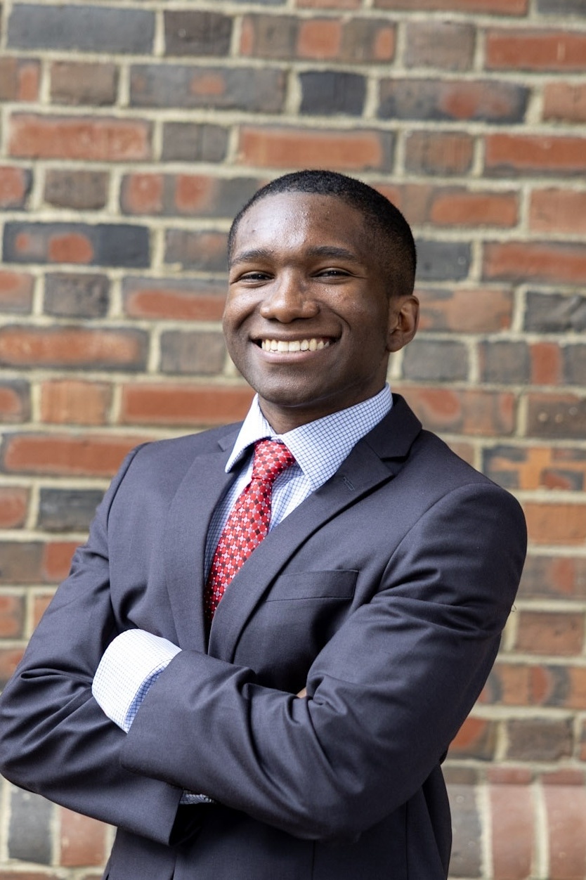 Jonathan Ancrum standing against a brick wall.