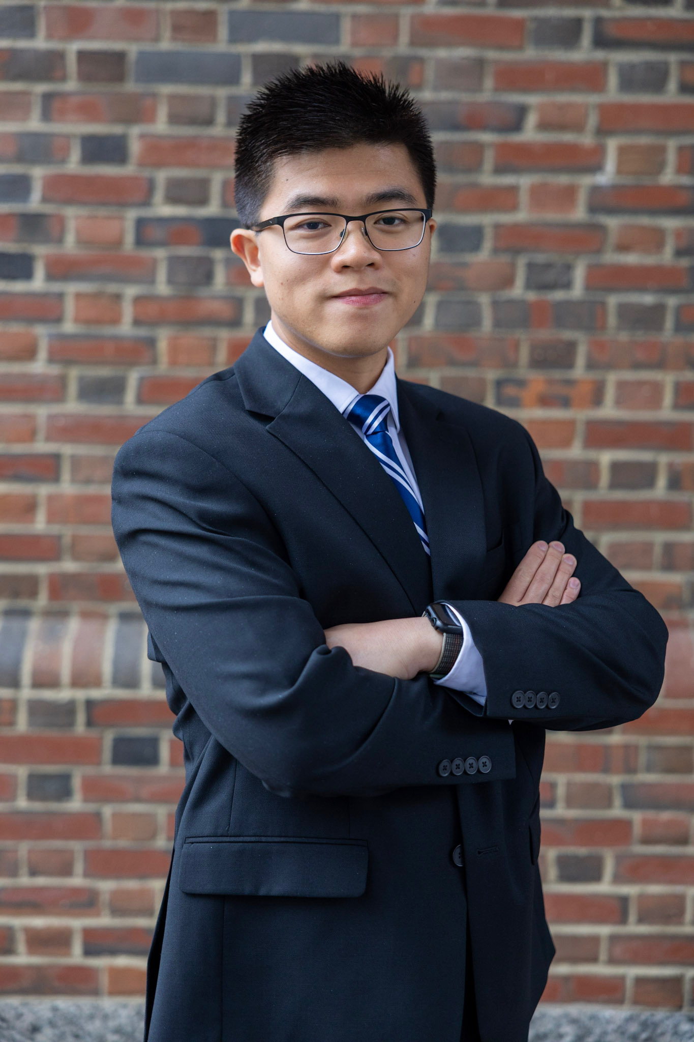 Vanston in a suit in front of a brick wall